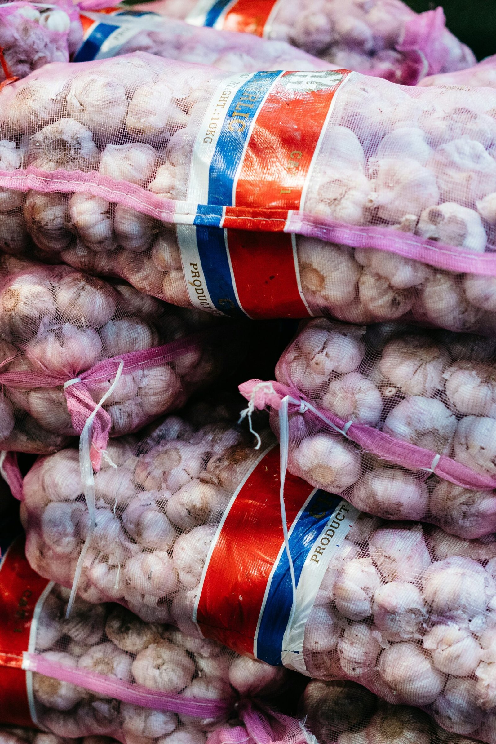 a pile of garlic sitting on top of a pile of bags